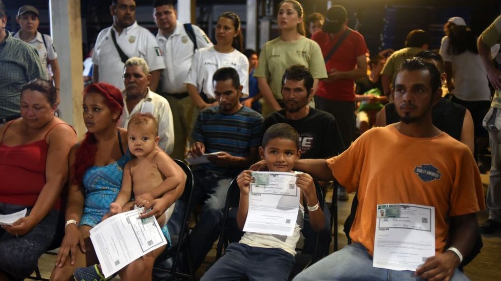 Migrantes centroamericanos sostienen su pase por razones humanitarias otorgado por las autoridades mexicanas.