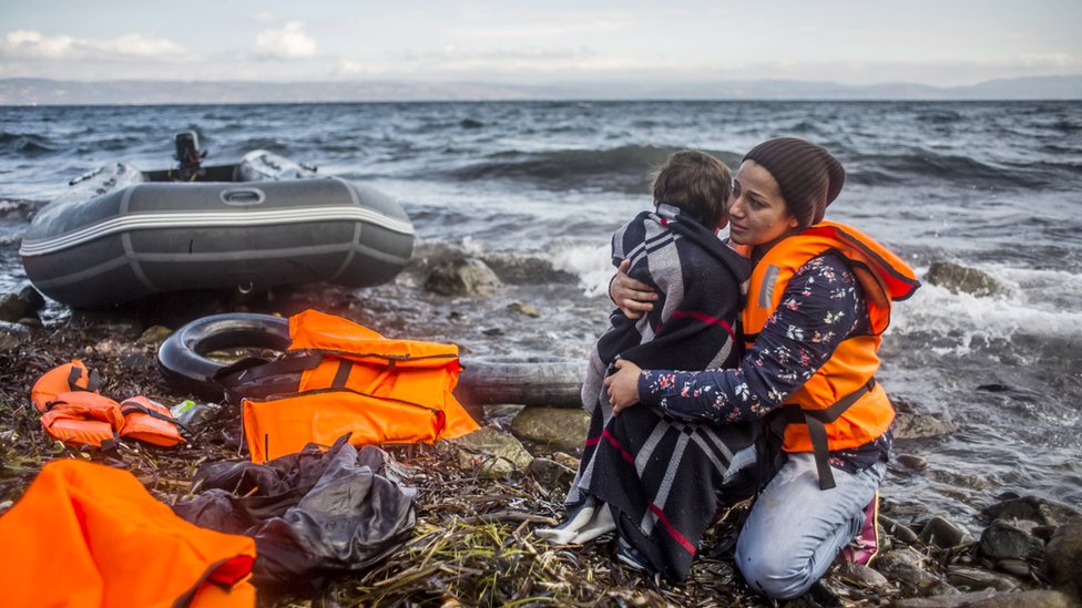 A woman holds her child as she arrived with other refugees on the shores of the Greek island of Lesbos