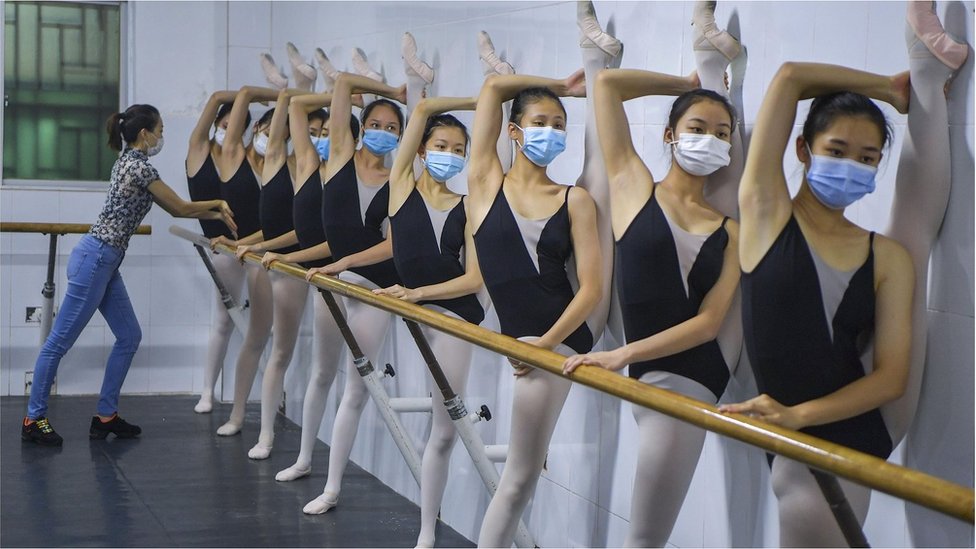 Students wearing face masks take part in a ballet training session at Ballet Dance School Affiliated to Hainan Provincial Song and Dance Troupe on April 15, 2020 in Haikou, Hainan Province of China.