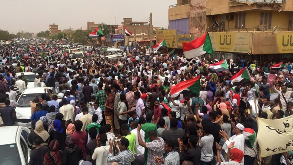 Суданские протестующие скандируют лозунги с требованиями гражданского правления 30 июня 2019 года во время митинга в южном районе Хартума Аль-Сахафа