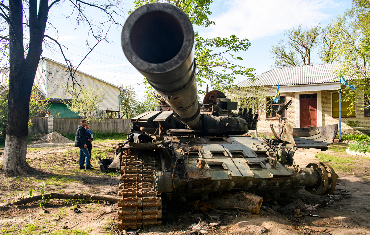 Habitantes locales junto a un tanque ruso destruido en Sloboda, en la ciudad de Chernígov, en el norte de Ucrania en mayo.
