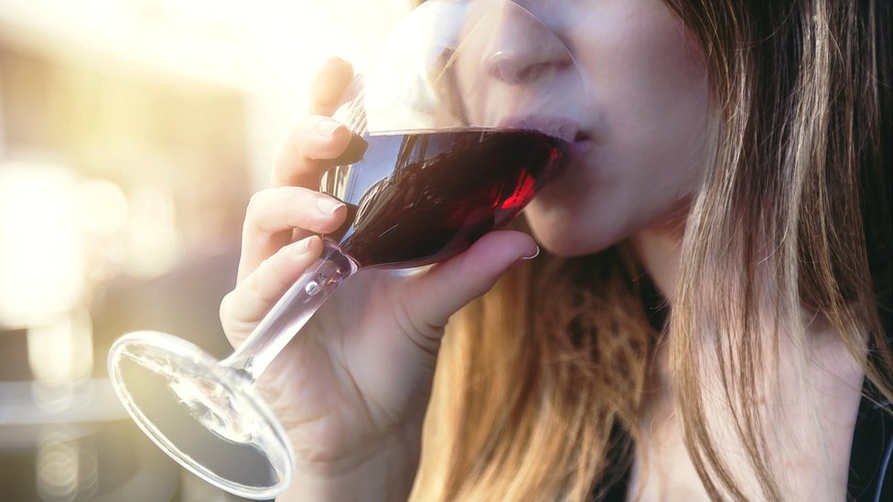 Mujer joven bebiendo alcohol.