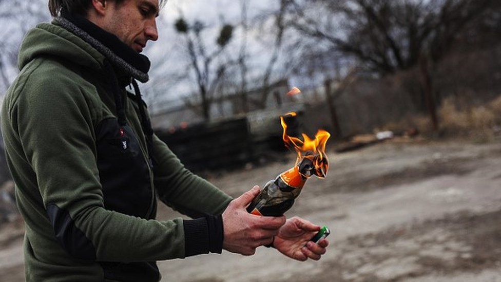 A man lights a Molotov cocktail