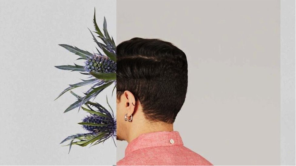 Back of man's head with flowers growing out of the front of his face