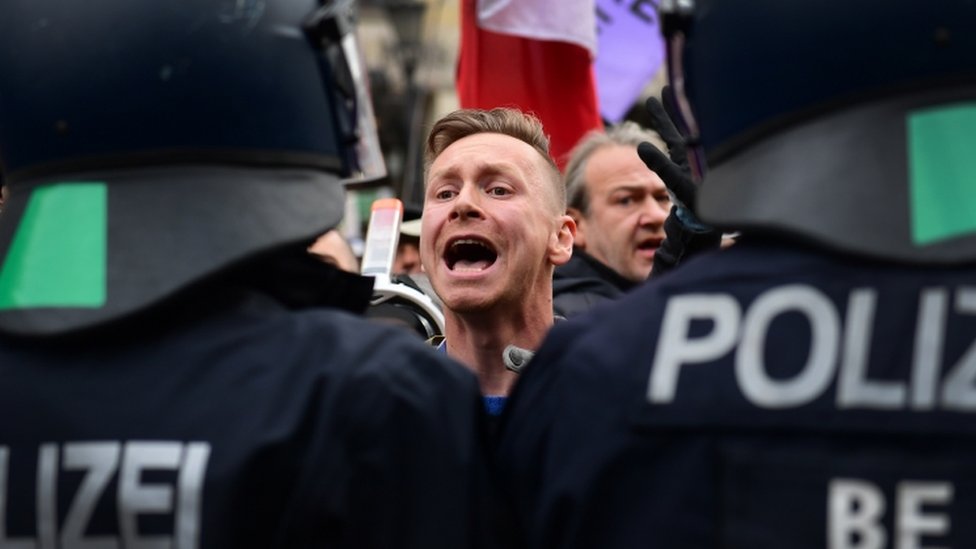 Протестующий кричит на полицейских во время демонстрации против ограничений на коронавирус в Германии, в Берлине, Германия, 18 ноября 2020 г.