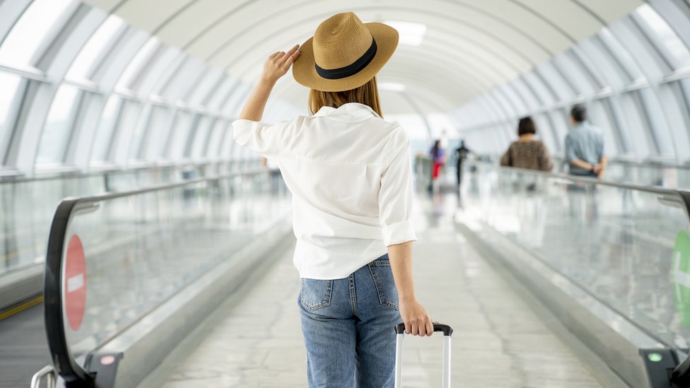 Havalimanında valiziyle bir kadın yolcu