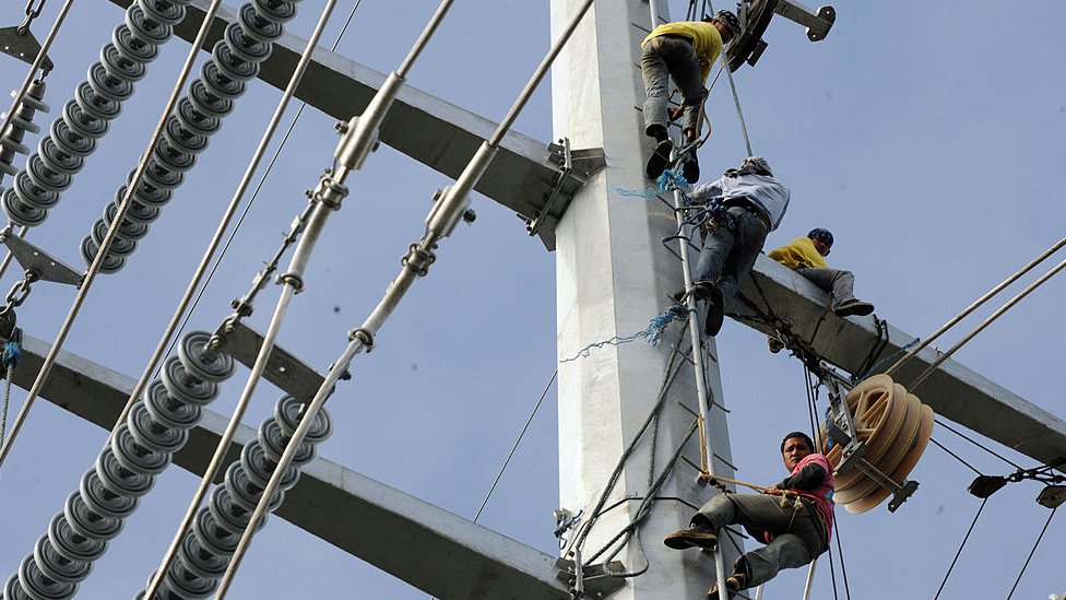 Линейщики прокладывают кабели на линии электропередачи Транско в городе Санта-Роза к югу от Манилы 15 января 2009 г.
