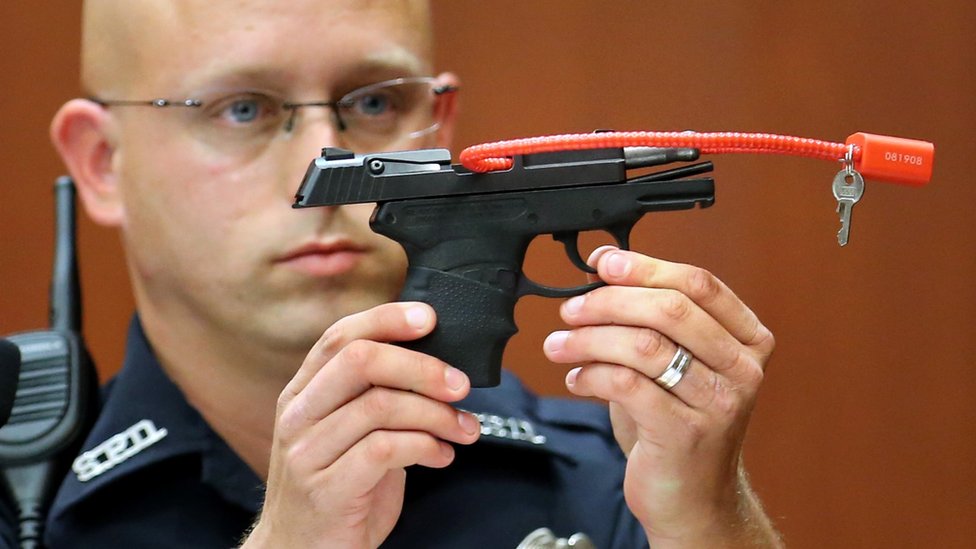 Полицейский из Сэнфорда Тимоти Смит держит пистолет, из которого убили Трейвона Мартина - июнь 2013 г.
