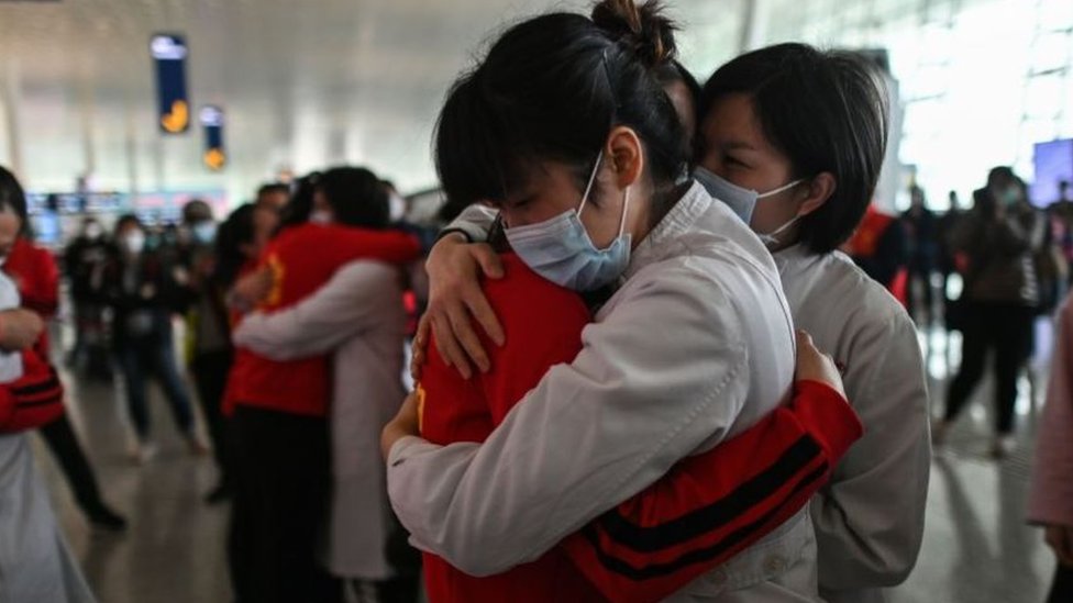 Tras semanas de intenso trabajo, personal médico de la emergencia sanitaria de Wuhan se despide de sus colegas en el aeropuerto de la ciudad.
