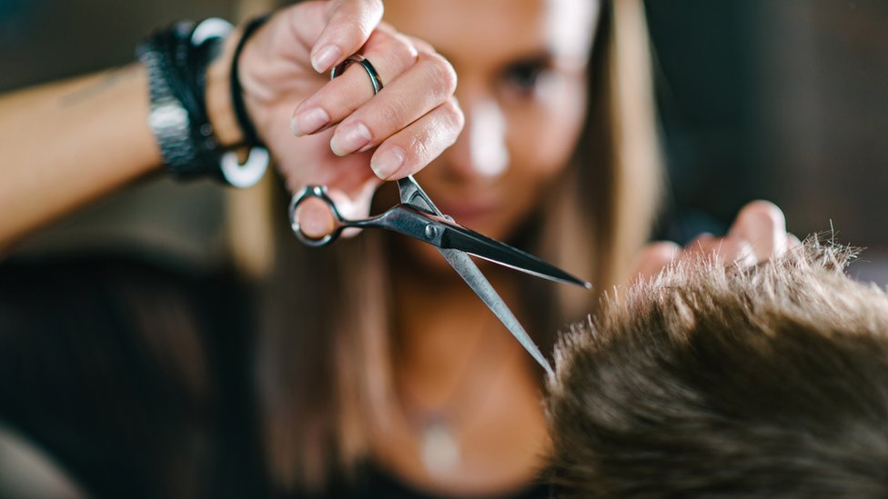Женщина стрижет волосы