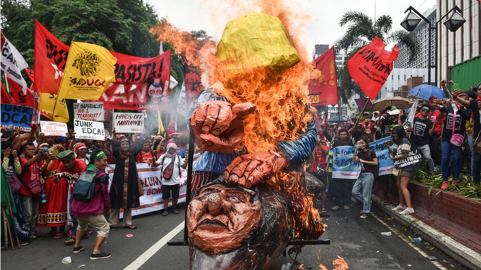 Антиамериканские протестующие сжигают чучела президента Дональда Трампа и президента Филиппин Родриго Дутерте во время митинга в Маниле в сентябре 2017 года