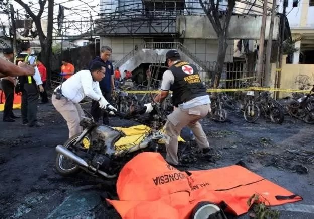 Sejumlah anggota kepolisian mengevakuasi rongsokan sepeda motor yang terbakar akibat ledakan bom di depan Gereja Pantekosta Pusat Surabaya (GPPS), Surabaya, Jawa Timur