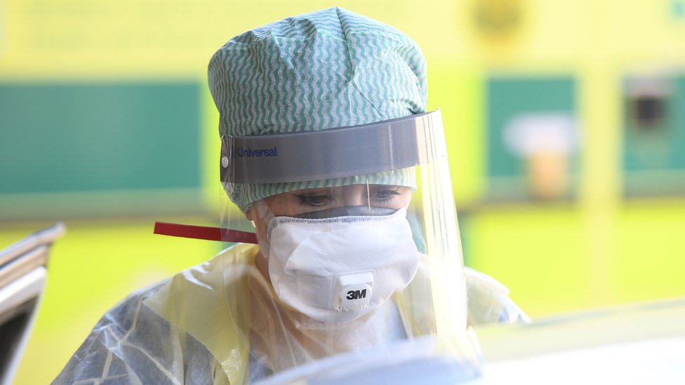 Медсестра отделения неотложной помощи во время демонстрации контейнера с коронавирусом