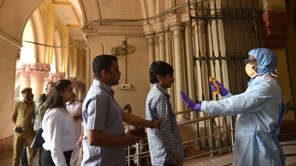 Врач Департамента здравоохранения штата Западная Бенгалия во вторник, 17 марта 2020 г., проводит тепловизионный скрининг для профилактики заражения коронавирусом (COVID-19) в Высоком суде Калькутты в Калькутте, Индия.