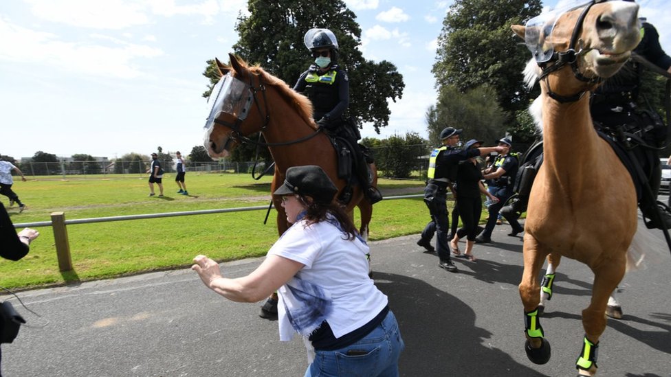 Полиция пытается перехватить протестующих во время акции протеста против изоляции в Мельбурне, Австралия, 19 сентября 2020 г.