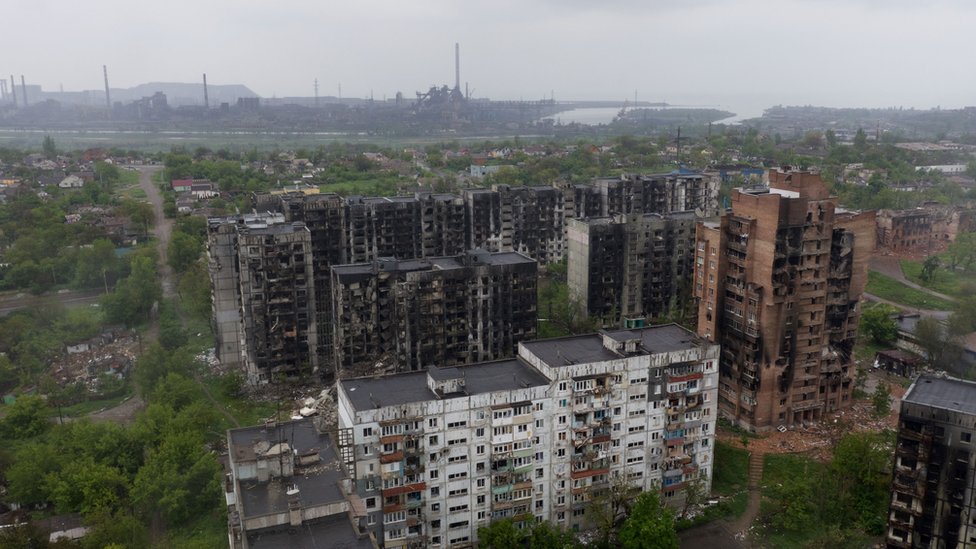 An aerial view of damaged residential buildings and the Azovstal steel plant in the background in the port city of Mariupol on May 18, 2022