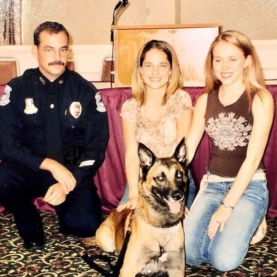 Kara con un policía, otra joven y un perro pastor alemán