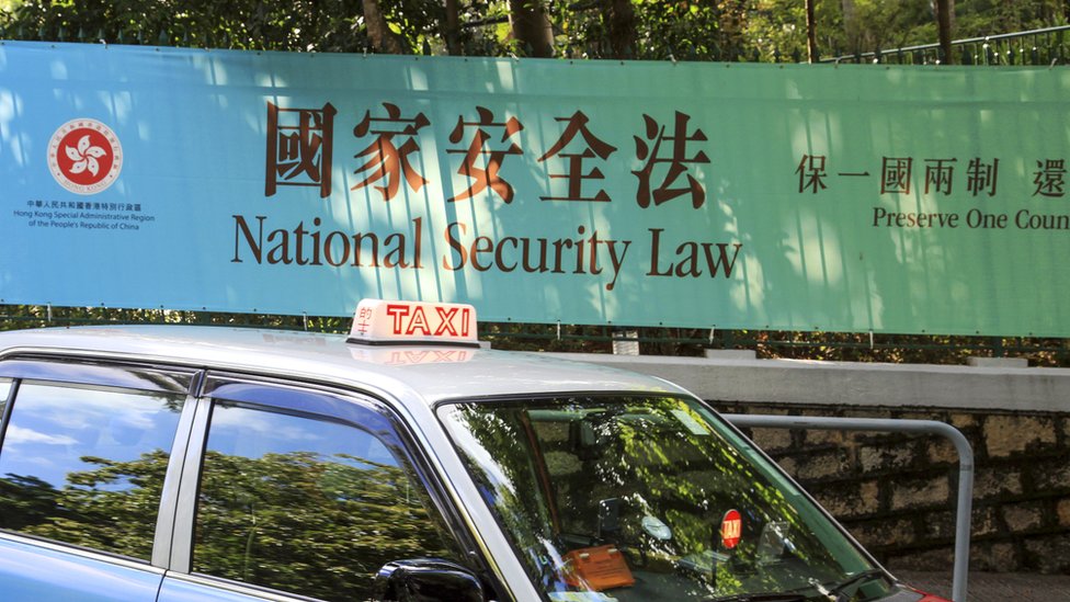 香港街頭一輛出租車駛過特區政府宣傳《香港國安法》大型橫幅（14/8/2020）