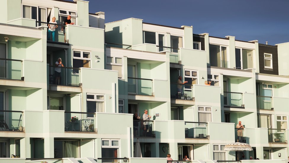 People clapping on a balcony