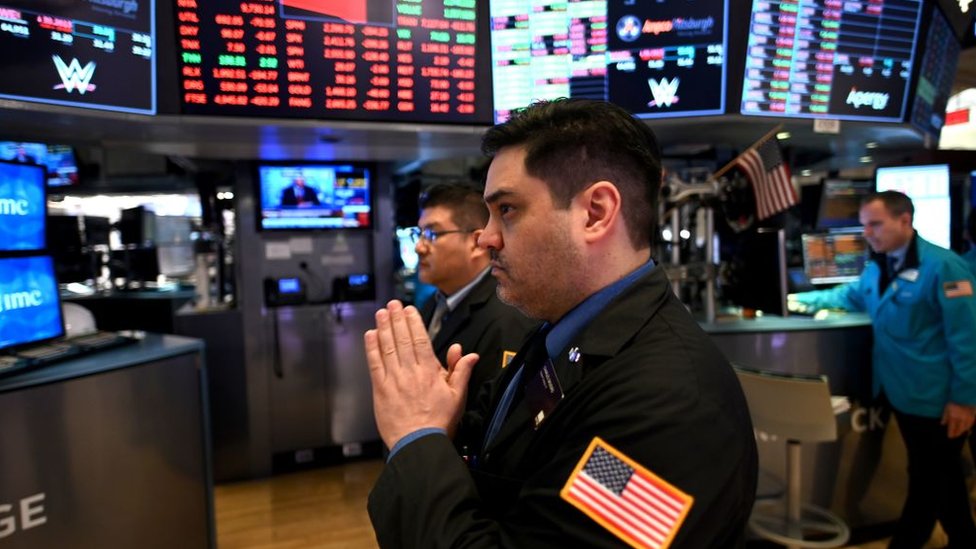Un hombre con las manos rezando en la Bolsa de Valores de Nueva York.