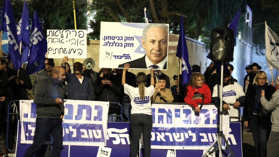 Сторонники Нетаньяху стоят возле резиденции премьер-министра с табличками