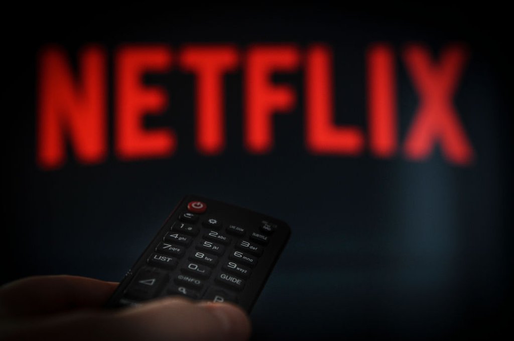 Un control de tv ante un letrero de Netflix