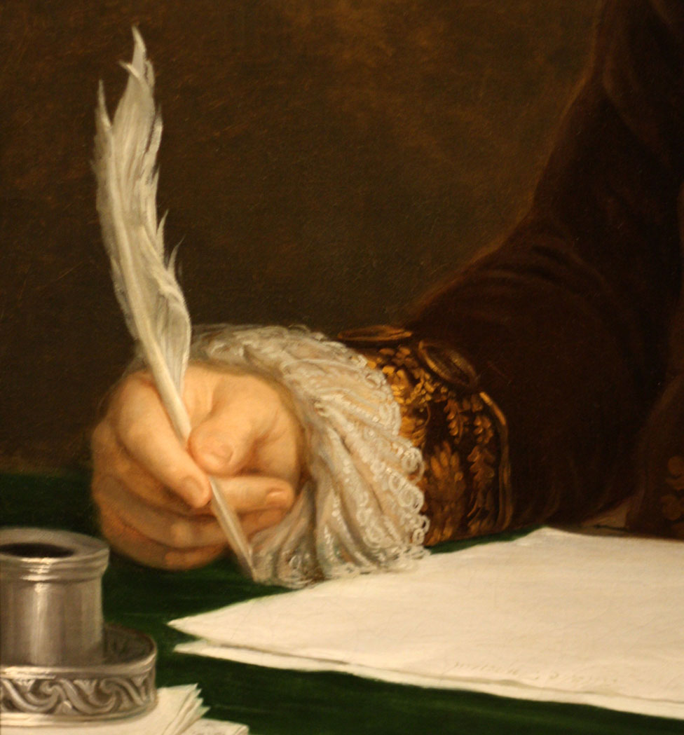 Una mano escribiendo una carta con una pluma