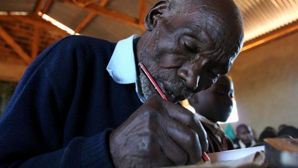 Kimani Maruge writing in a notebook