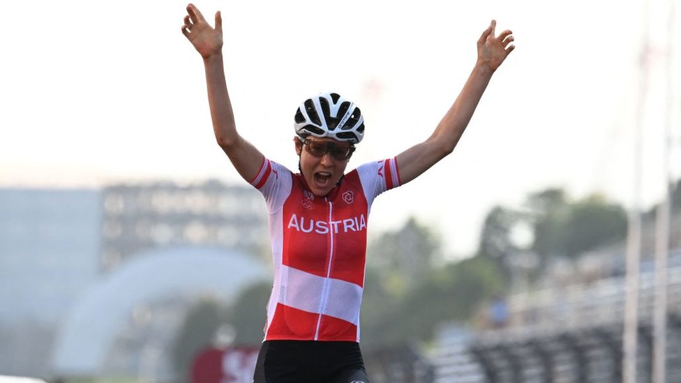 Anna Kiesenhofer, de Austria, levanta los brazos al ganar la prueba de ciclismo de ruta en Tokyo 2020