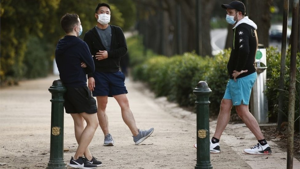 Tres hombres con mascarilla en Melbourne