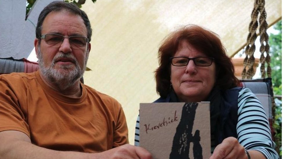 Bernd and Ulla Brammer hold a booklet showing the name of their ancestor 'witch'
