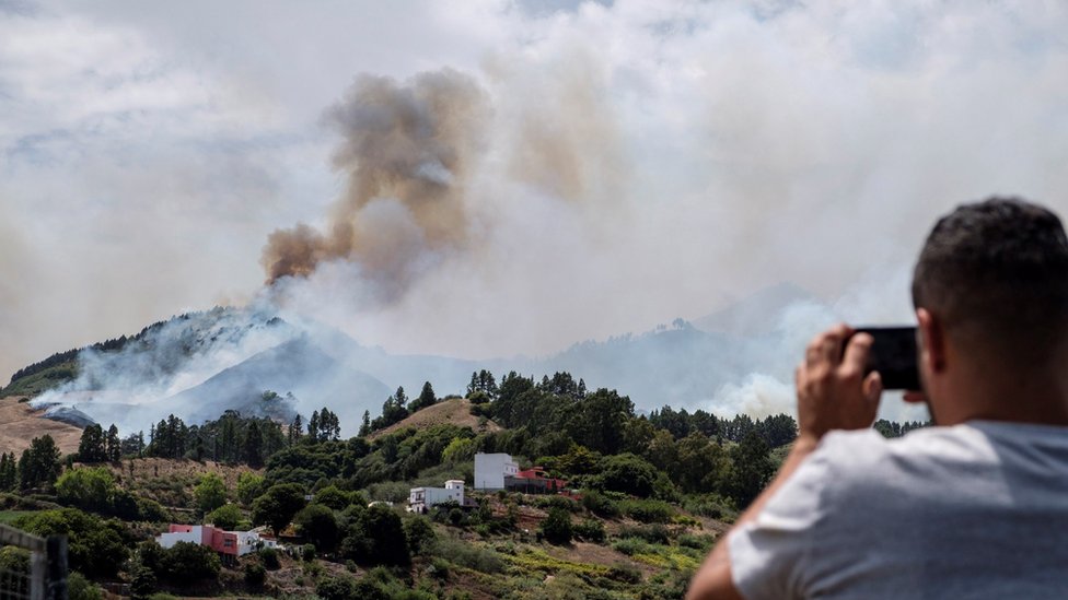 Мужчина фотографирует на свой смартфон во время лесных пожаров на Гран-Канарии