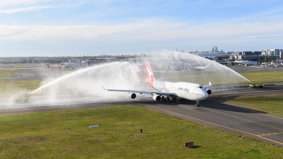 Qantas Boeing 747-400, регистрационный номер VH-OEJ, получает салют из водометов в аэропорту Сиднея