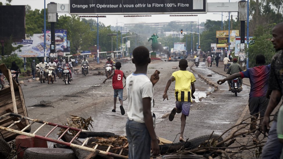 Люди убегают по прибытии ОМОНа, когда протестующие устанавливают баррикады в Бамако