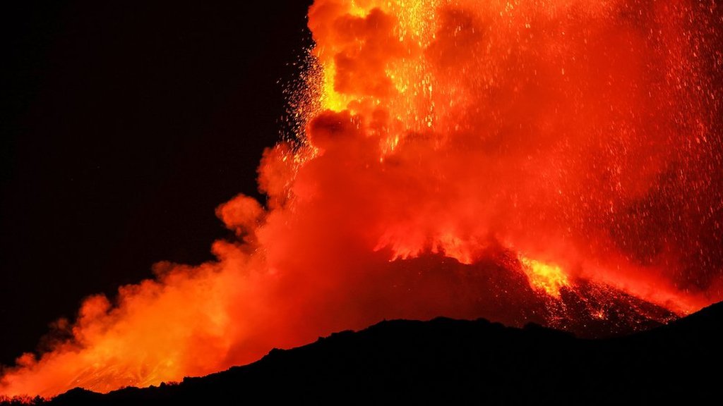 Lava fountains spewing from the top of the volcano