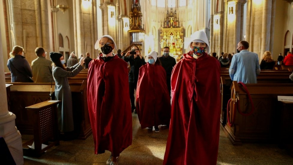 Protesters walk through a cathedral in Lodz, Poland