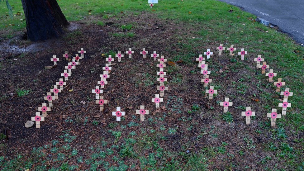 Wooden crosses are seen arranged to form the number one hundred to mark Remembrance on the grounds of St Mary's church in Isleworth, London