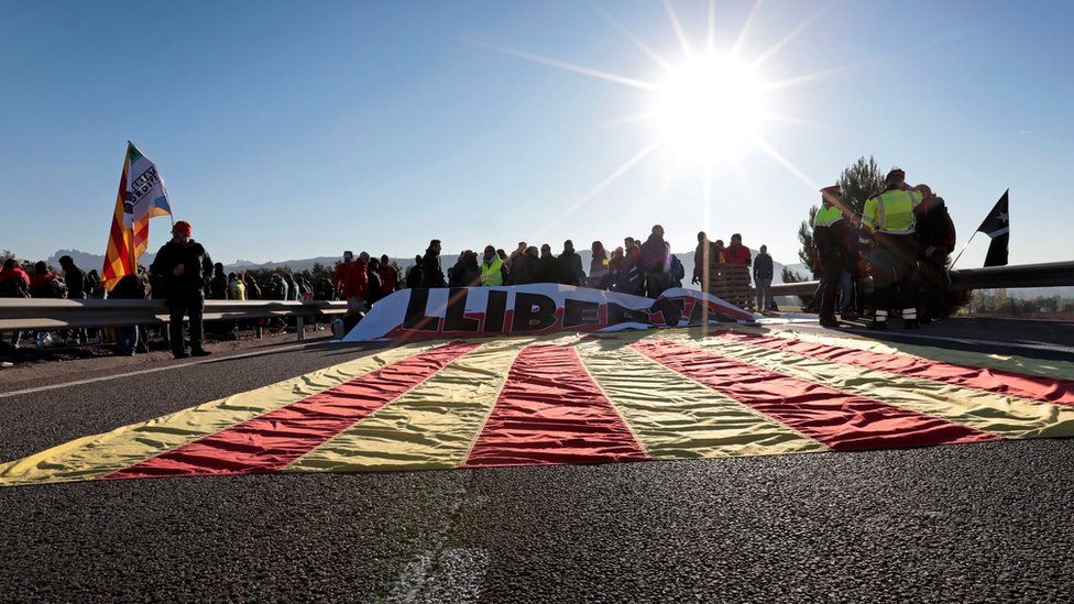 A Catalan flag is seen on the A-2 motorway as protesters block a road during a strike in Odena, Barcelona