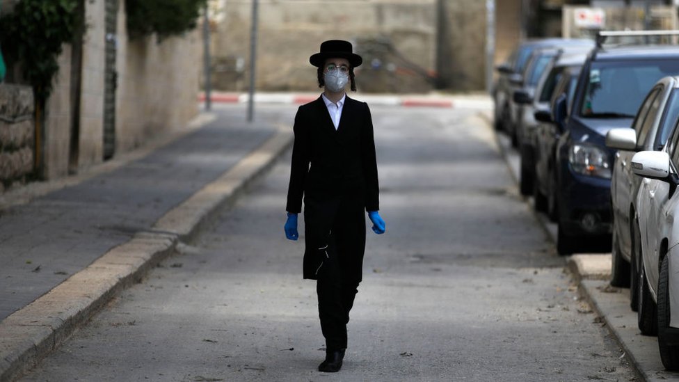 Niño ultraortodoxo con mascarilla y guantes en Jerusalén.
