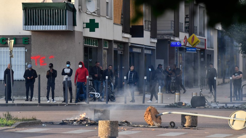 Люди стоят на разрушенной улице в Дижоне в понедельник