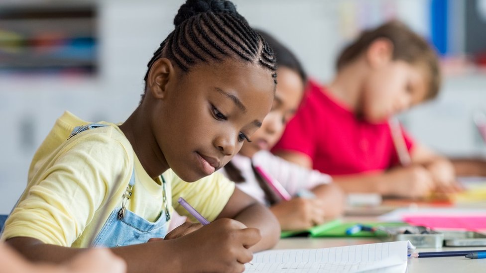 Una niña en un escritorio de una escuela.