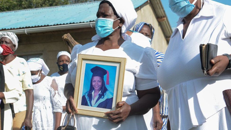 Grace Lugaliki (2nd R) holds a portrait of her daughter Dr. Doreen Lugaliki, 39, the first Kenyan doctor who died of the COVID-19 coronavirus in Nairobi, during her daughter's funeral in Ndalu, western Kenya, on July 13, 2020