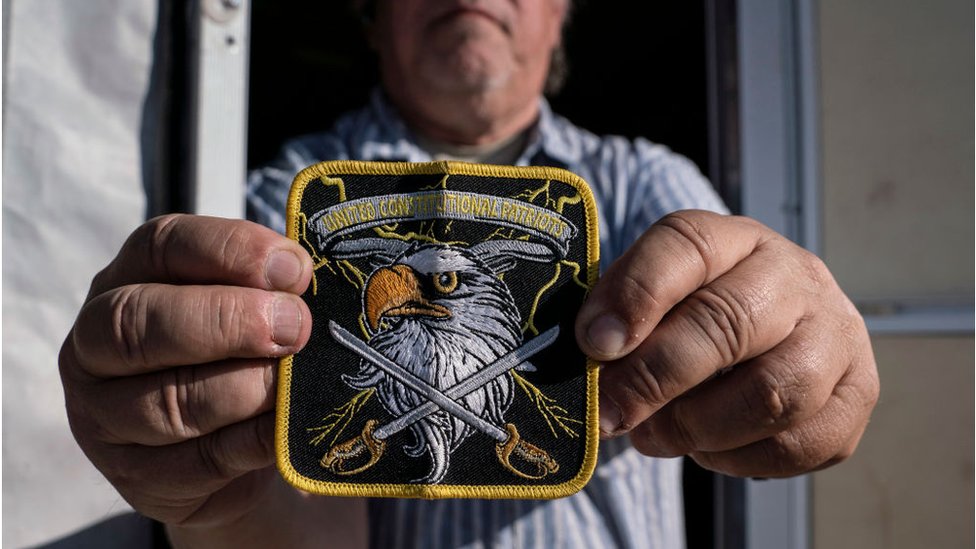 Член отряда ополчения United конституциональных патриотов пограничной службы штата Нью-Мексико показывает нашивку своей группы возле своего кемпинга в Анапре, штат Нью-Мексико, 20 марта 2019 года.