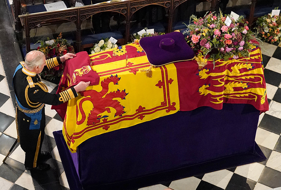 King Charles III places the the Queen's Company Camp Colour of the Grenadier Guards on the coffin at the Committal Service for Queen Elizabeth II, held at St George's Chapel in Windsor Castle, Berkshire