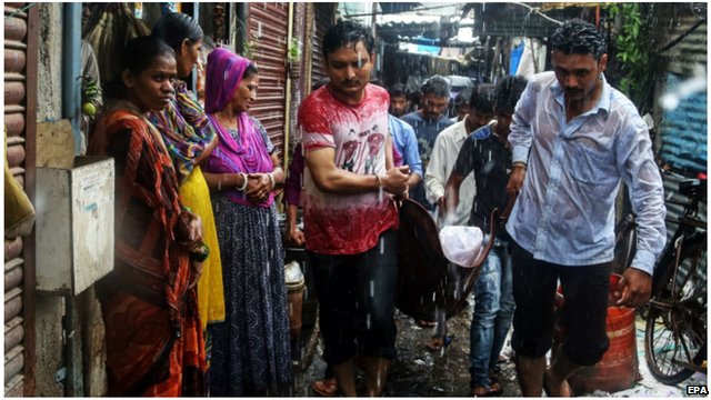 A man is carried on a stretcher following toxic liquor consumption