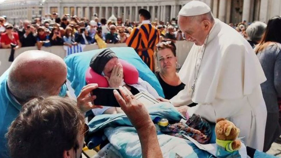 Pope Francis blessing a terminally ill patient