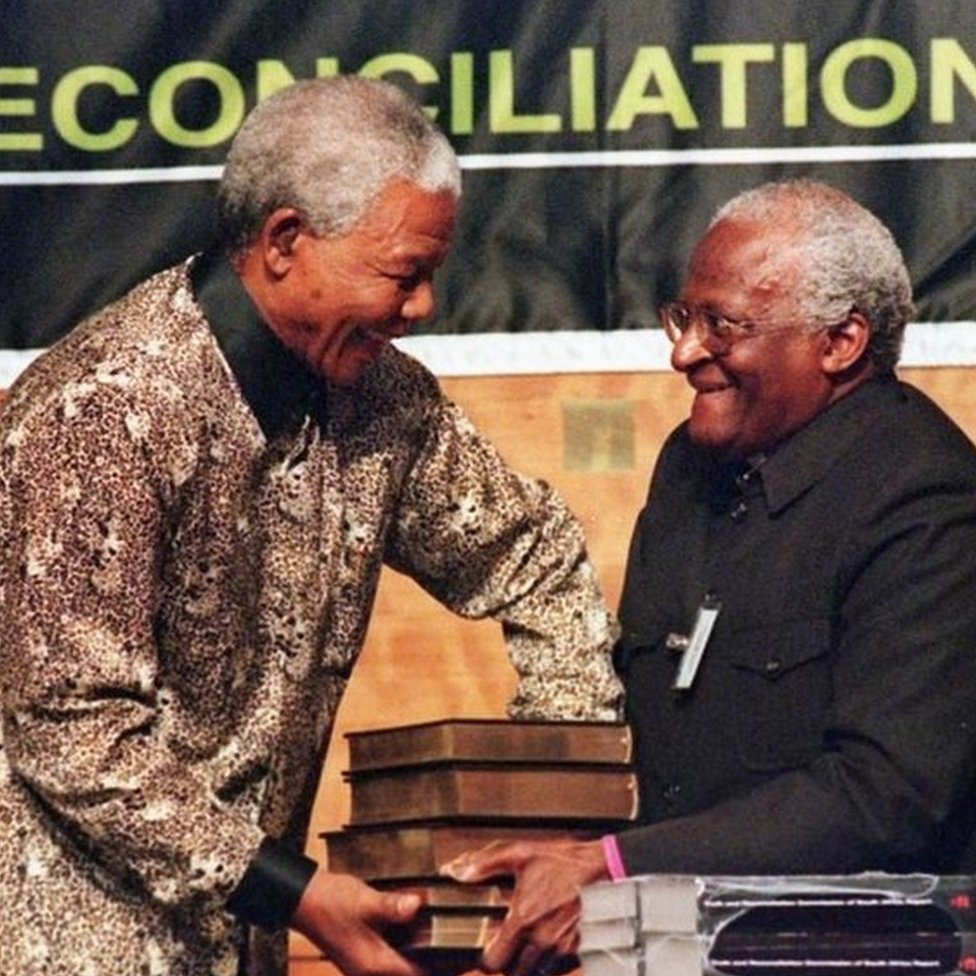 Tutu hands the report of the Truth & Reconciliation Commission to Mandela