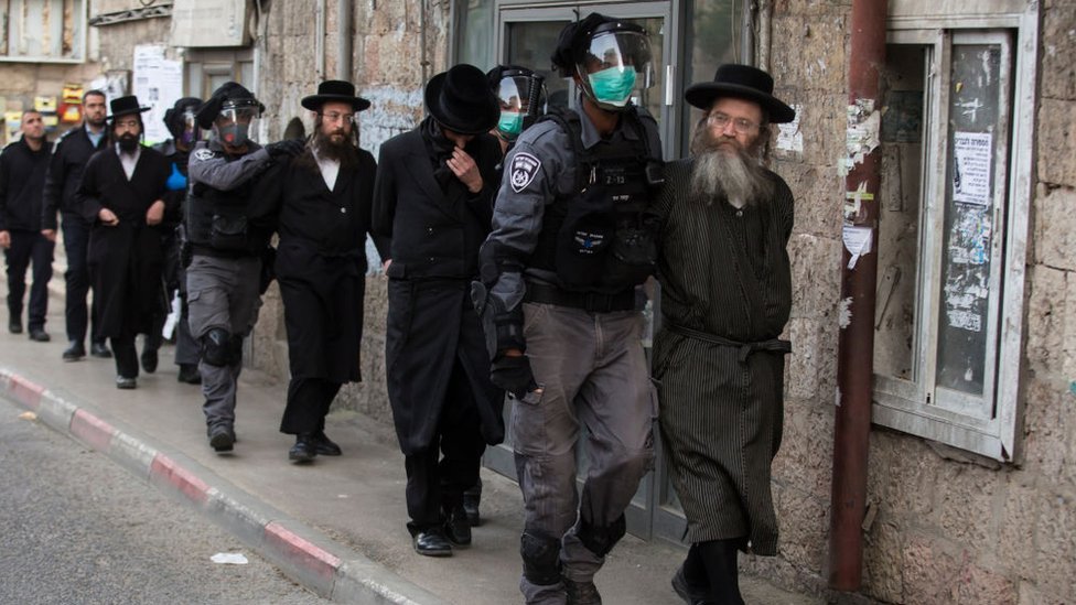 Policías detienen a hombres ultraortodoxos.