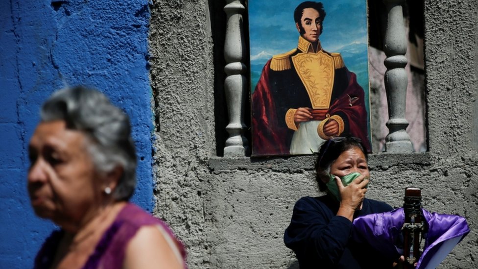 Женщина в защитной маске реагирует на проходящую мимо процессию Назарянина Святого Павла, несмотря на общенациональный карантин из-за вспышки коронавирусной болезни (COVID-19) в Каракасе, Венесуэла 8 апреля 2020 г.
