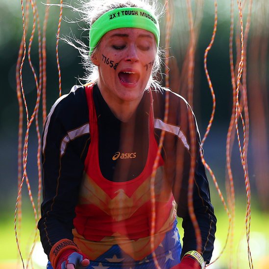 Los obstáculos van evolucionando con el paso de los años y nuevos desafíos son incorporados para exigir más a los participantes. Mujer pasando por la cortina de cables con corriente